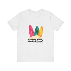 The Diabuddies Store Catching Waves, Checking Levels (Surf Boards) - Unisex Tee Hit the beach or the studio in comfort with our "Catching Waves, Checking Levels..." tee, designed for everyone, including those managing diabetes. T-Shirt Awareness clothing,